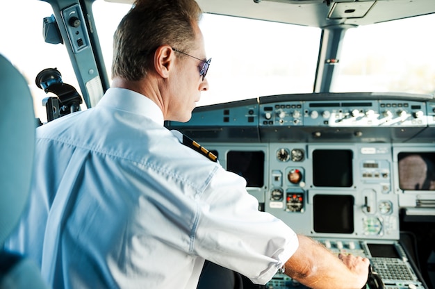 Fertig zum Abheben. Rückansicht eines selbstbewussten männlichen Piloten, der im Cockpit sitzt