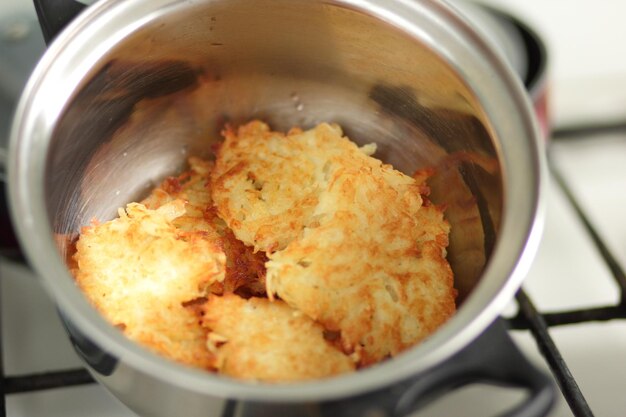 Fertige hausgemachte Kartoffelpuffer in einem Topf in einer heimischen Küche Vegetarisches Essenskonzept Nahaufnahme