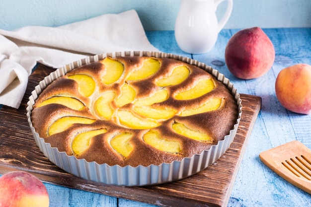 Fertiger frischer Pfirsichkuchen in einer Auflaufform auf dem Tisch Hausgemachter Nachtisch