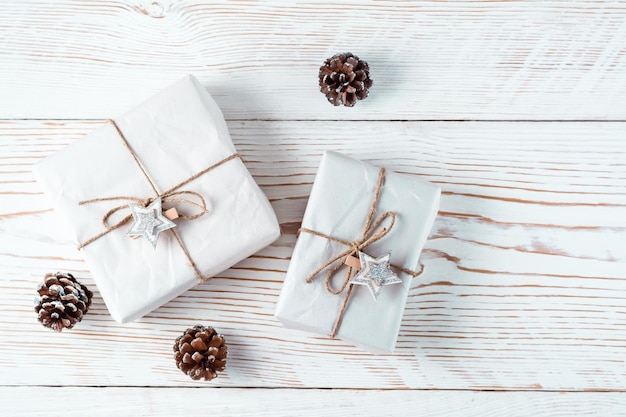 Foto fertiggefertigte weihnachtsgeschenke, verpackt in handwerkspapier, mit einem silberstern mit schnur gebunden, umweltfreundlich