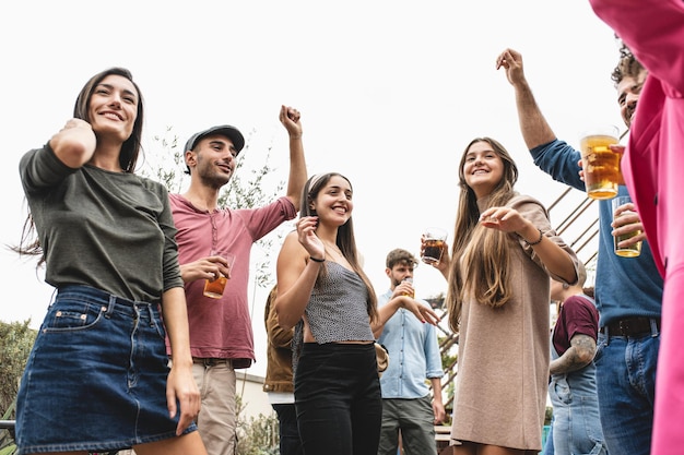 Festa dançante no telhado de um prédio com faixa etária mista brindando e celebrando os feriados