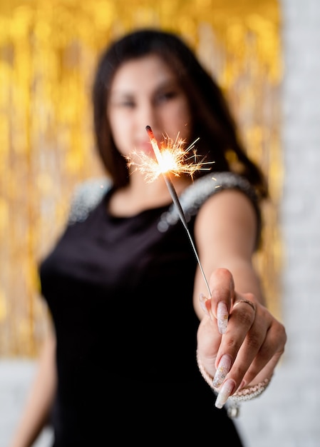 Foto festa de aniversário. mulher jovem e bonita segurando diamante e balão em fundo dourado