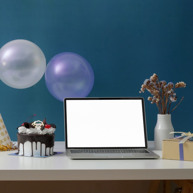 Festa de aniversário online com laptop de tela em branco, bolo, chapéu de festa e decorações