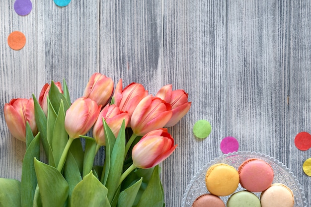 Festa de aniversário plana leigos com tulipas e doces laranja jn uma bandeja decorativa em madeira cinza texturizada