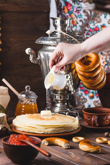 Foto festa de chá com panquecas, chá samovar e picles.