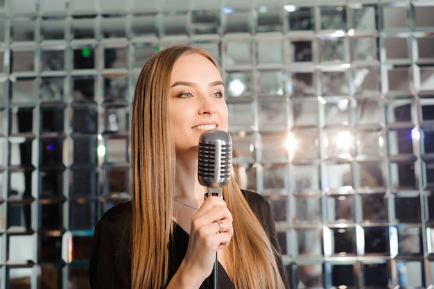 Festa de karaoke. menina de beleza com um microfone cantando.