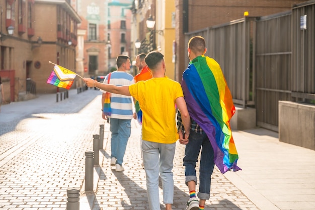 Festa do orgulho gay na cidade, casais de homens caminhando de costas para a manifestação com o conceito lgbt de bandeiras de arco-íris