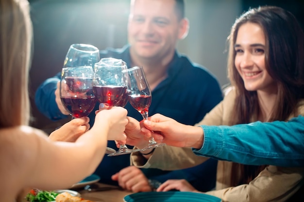 Foto festa em um restaurante. amigos se divertem em um restaurante e bebem vinho. humor festivo.