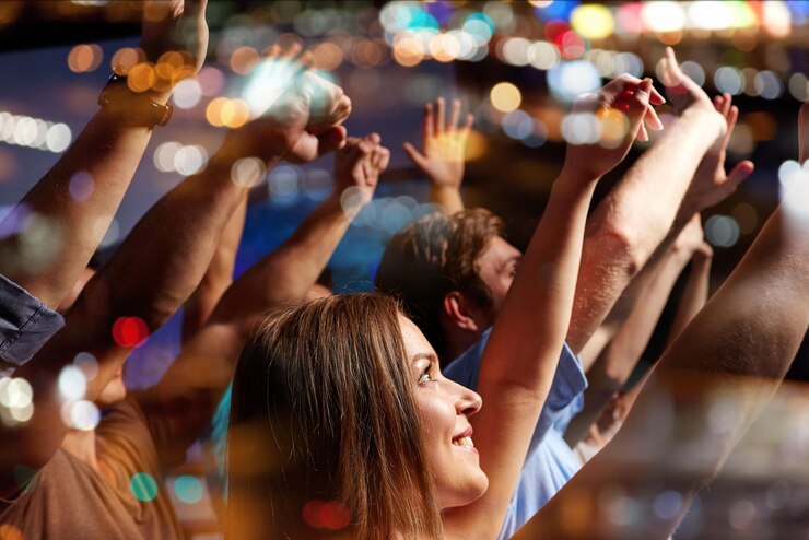Foto festa, feriados, celebração, vida noturna e conceito de pessoas - amigos sorridentes acenando as mãos no concerto no clube