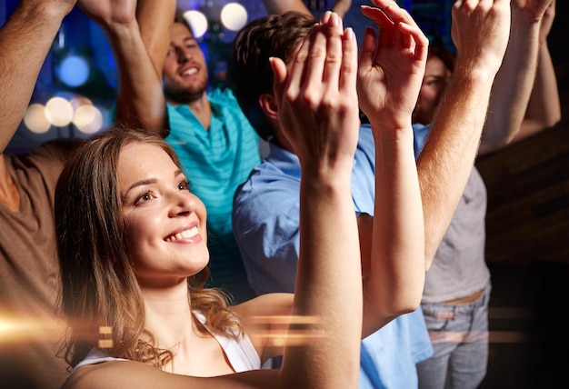 Festa, feriados, celebração, vida noturna e conceito de pessoas - amigos sorridentes aplaudindo no concerto no clube