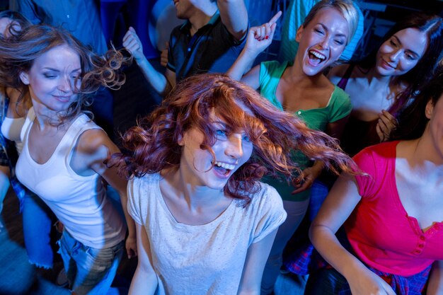 festa, feriados, celebração, vida noturna e conceito de pessoas - amigos sorridentes dançando no clube