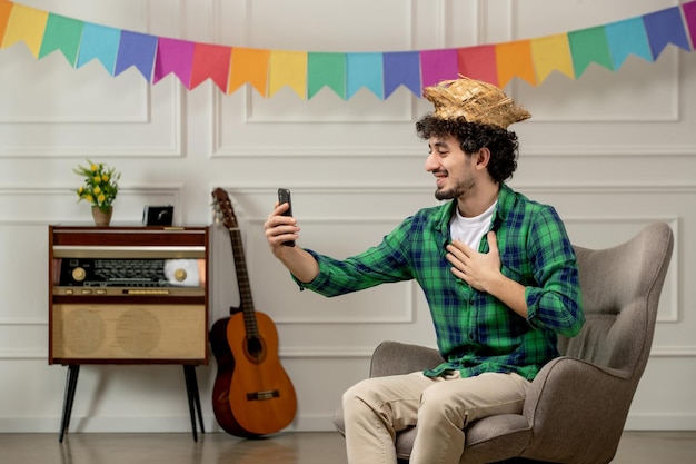 Festa junina bonitinho de chapéu de palha com rádio retrô e bandeiras coloridas falando em videochamada