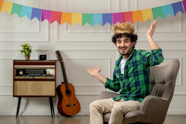 Festa junina lindo joven con sombrero de paja con radio retro y banderas coloridas agitando las manos