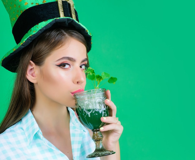 Festeira na mulher pin-up de Patricks Day em estilo verde com cerveja.