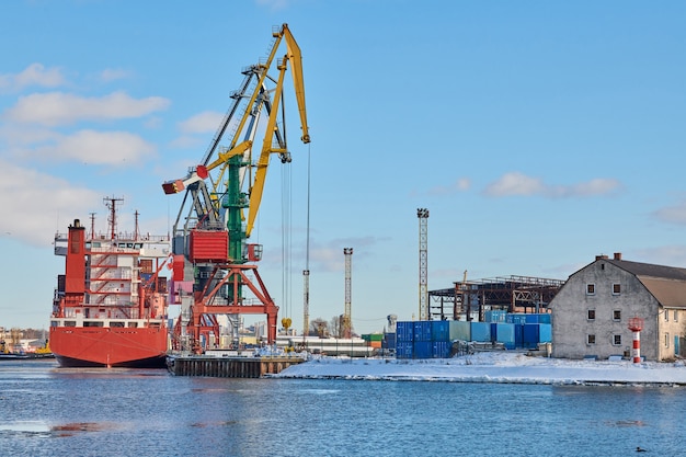 Festgemachte Frachtschiffe und Hafenkräne im Hafen. Seehafen, Frachtcontainerhof, Containerschiffsterminal, Werft. Wirtschaft und Handel, Logistik