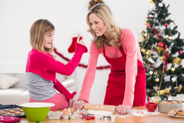 Festiva madre e hija haciendo galletas de Navidad