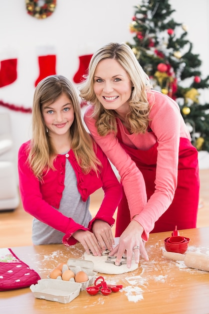 Festiva madre e hija haciendo galletas de Navidad