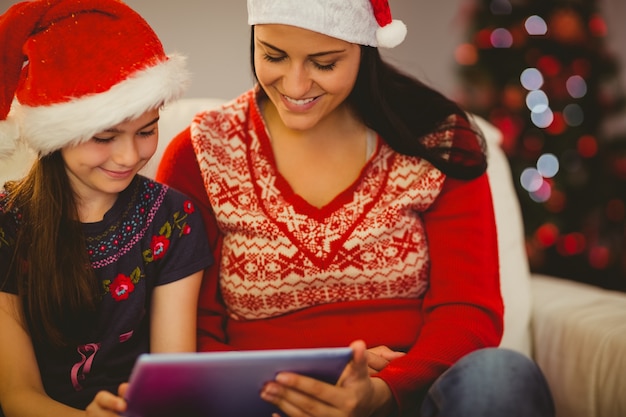 Festiva mãe e filha usando o tablet