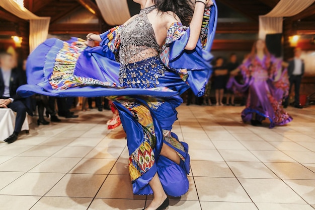 Festival de danza gitana Mujer interpretando danza romaní y canciones folclóricas con ropa nacional Hermosas chicas gitanas bailando con vestido floral tradicional en la recepción de la boda en el restaurante