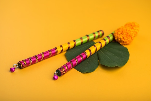 Foto festival indiano dussehra e navratri, mostrando folha dourada (bauhinia racemosa) e flores de calêndula com varas dandiya.