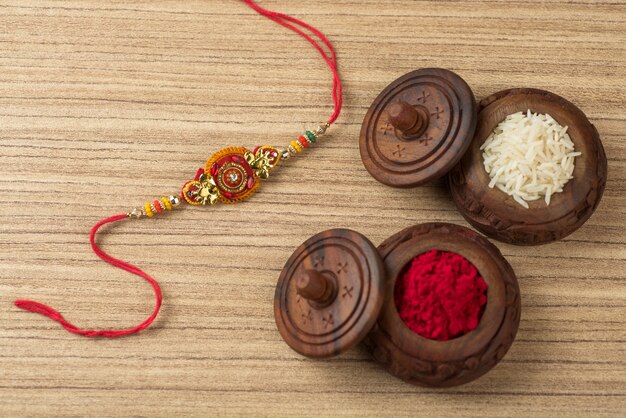 Festival indiano: fundo Raksha Bandhan com um elegante Rakhi, grãos de arroz e Kumkum