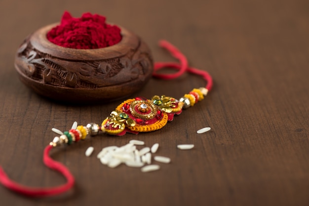 Festival indiano: Raksha Bandhan com um elegante Rakhi, grãos de arroz e Kumkum. Pulseira tradicional indiana, símbolo de amor entre irmãos e irmãs.