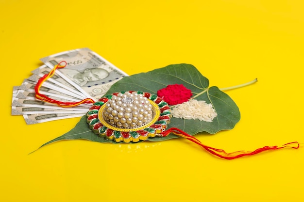 Foto festival indiano raksha bandhan uma pulseira tradicional indiana com kumkumrise e moeda indiana