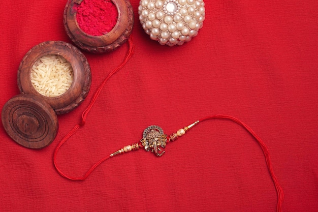 Festival indiano Raksha Bandhan Uma pulseira tradicional indiana em fundo vermelho