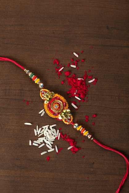 Festival indio: celebración de Raksha Bandhan con un elegante Rakhi, Rice Grains y Kumkum. Una pulsera tradicional india que es un símbolo de amor entre hermanos y hermanas.