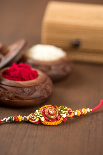 Festival indio: fondo de Raksha Bandhan con un elegante Rakhi, granos de arroz y Kumkum