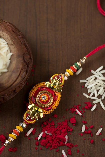 Festival indio: fondo de Raksha Bandhan con un elegante Rakhi, granos de arroz y Kumkum