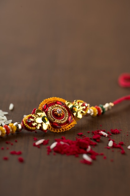 Festival indio: fondo de Raksha Bandhan con un elegante Rakhi, granos de arroz y Kumkum