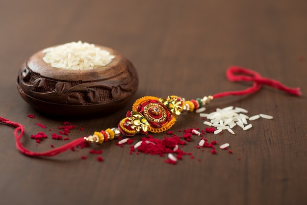 Festival indio: Raksha Bandhan con un elegante Rakhi, granos de arroz y Kumkum. Una pulsera tradicional india que es un símbolo del amor entre hermanos y hermanas.