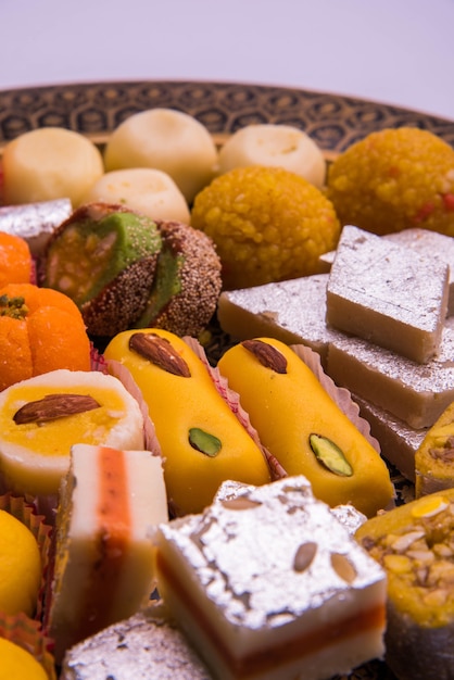 Festival indio surtido de alimentos dulces o mithai sobre fondo blanco.