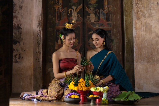 Festival de loy krathong tailandia. las mujeres asiáticas son loy krathong en el río por la noche.