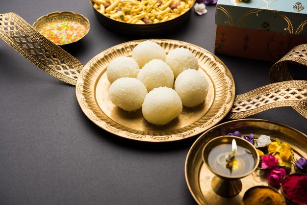 Festival Raksha bandhan: Rakhi conceptual elaborado con plato lleno de dulce Rasgulla con banda. Una pulsera tradicional india que es un símbolo del amor entre hermanos y hermanas.