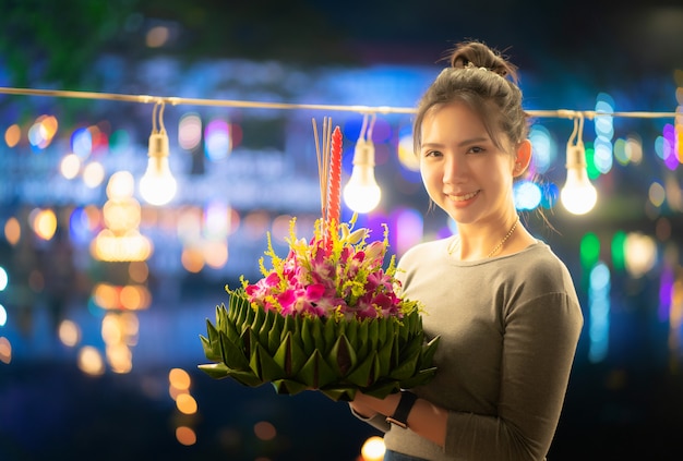 Festivales de Loy Krathong en Tailandia Hermosa mujer sostiene krathong con hoja de plátano para creer buena suerte y gracias río de agua