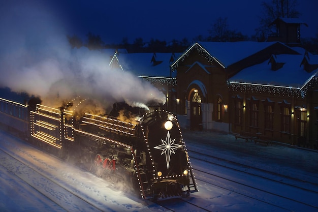 festivamente decorado com luzes retrô trem de Natal nos trilhos, noite de neve