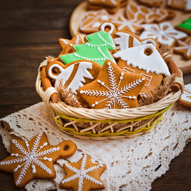 Las festivas galletas de jengibre navideñas en forma de estrella yacen sobre una mesa de madera de color marrón oscuro