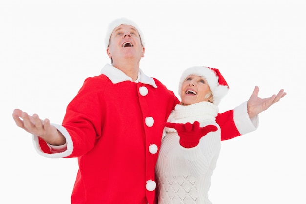 Festive pareja sonriendo y mirando hacia arriba