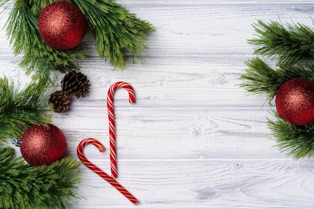 Festivo com bastões de doces e enfeites de Natal em uma placa de madeira