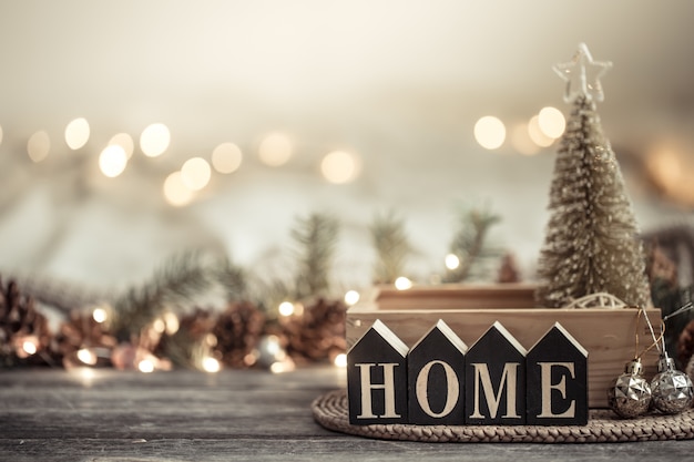 Festivo con luces y la inscripción a casa en una mesa de madera. Con artículos de decoración festiva.