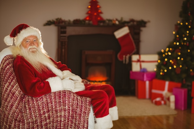 Festivo Papai Noel sentado no sofá no Natal