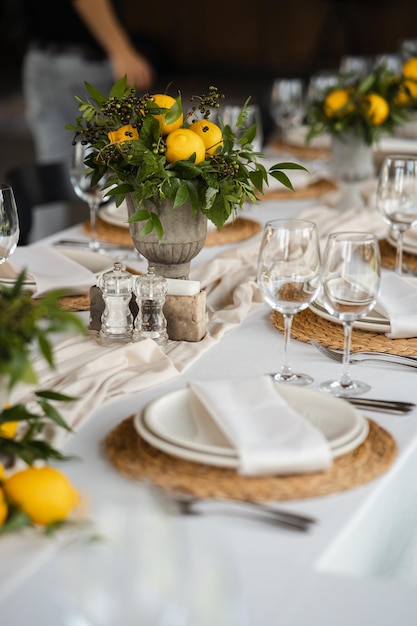 Festlich gedeckter Tisch auf der Hochzeitsfeier mit Zitronenarrangements geschmückt