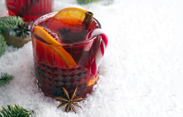 Festlich stilisierter Cocktail auf dem Schnee und verstreuten Fichtenzweigen