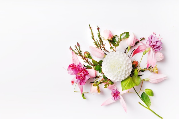 Festliche Blumenkomposition auf der Draufsicht des weißen hölzernen Hintergrundes