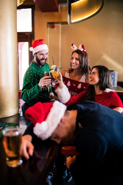 Festliche Freunde, die Bier und Cocktail trinken