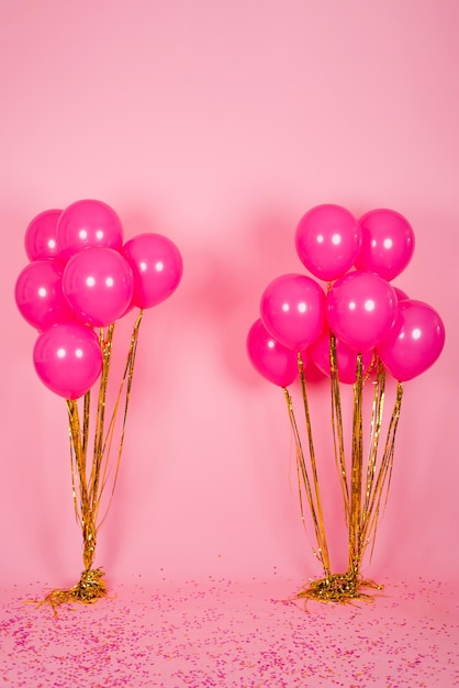 Festliche fuchsiafarbene oder rosa Luftballons mit Goldfäden, die in einem Blumenstrauß zum Geburtstag, Valentinstag oder Muttertag gesammelt werden