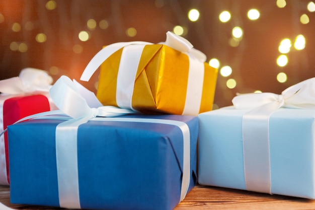 Festliche Geschenkbox auf Holztisch gegen braunen bokeh Hintergrund