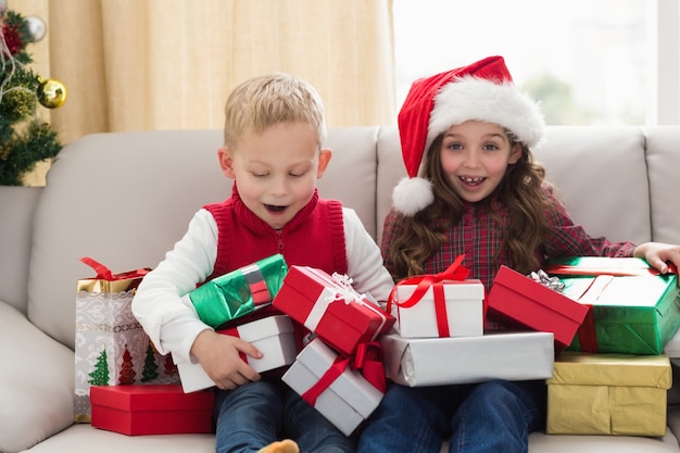 Festliche Geschwister, umgeben von Geschenken